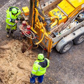 Surveyor examines the ground by drilling. Surveying workers drill a hole in the ground to check the ground. view from above. Geodetic soil investigation.
